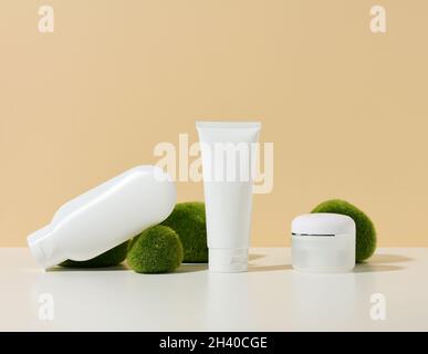 Tube en plastique blanc vide, bol avec un broyeur à proximité de pierres avec de la mousse sur un fond beige.Produits cosmétiques pour le gel de marquage, cr Banque D'Images