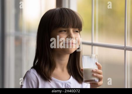 Joyeux enfant avec une moustache laiteuse drôle et du lait frais et sain Banque D'Images