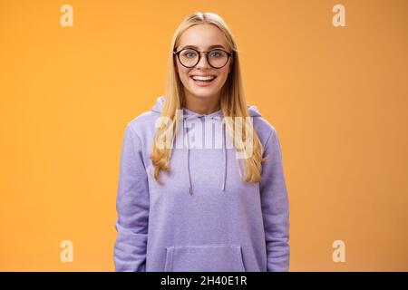 Charmante femme étudiante geek souriant énergique wanna participer à l'événement universitaire grinning look excité portant des lunettes violet h Banque D'Images