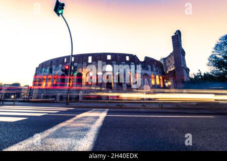 Colisée de nuit Rome Italie avec lumières longue exposition.Circulation en mouvement rapide, voitures de bus. Banque D'Images