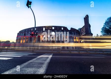 Colisée de nuit Rome Italie avec lumières longue exposition.Circulation en mouvement rapide, voitures de bus. Banque D'Images