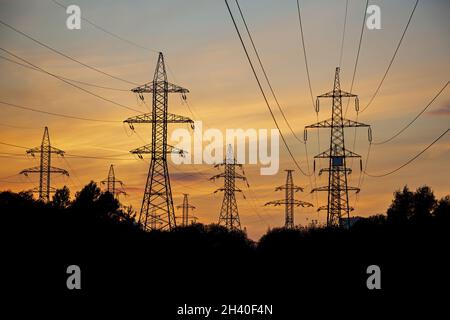 Ligne de fils haute tension pendant le coucher de soleil panoramique Banque D'Images