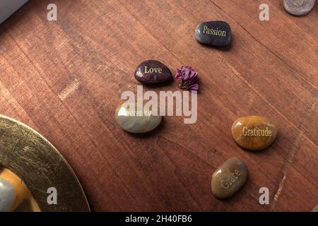 Pierres motivationnelles inspirantes avec des écrits.Sérénité, gratitude, passion, amour sur fond de table rouge Banque D'Images