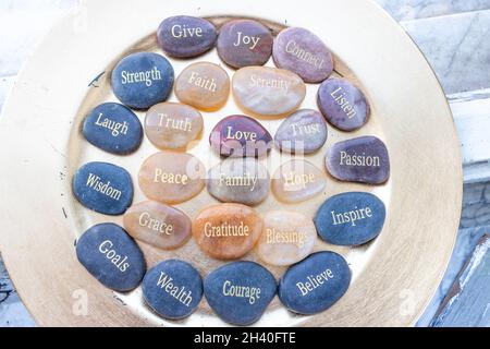 Pierres d'inspiration zen motivationnelle avec des écrits.Sérénité, gratitude, passion, croire, amour sur un fond doré Banque D'Images