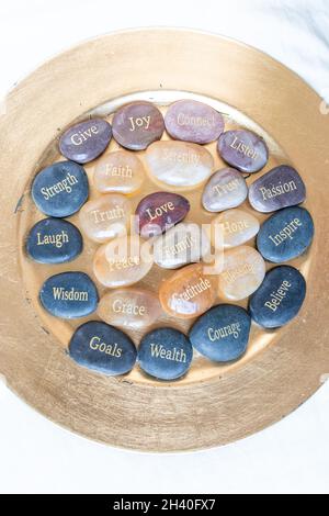 Pierres d'inspiration zen motivationnelle avec des écrits.Sérénité, gratitude, passion, croire, amour sur un fond doré Banque D'Images