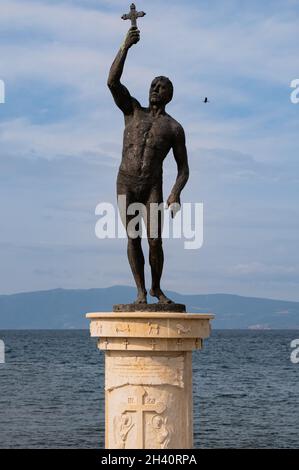 OHRID, MACÉDOINE DU NORD - 26 AOÛT 2021 : statue en bronze d'un homme tenant une croix dans sa main droite en face du lac Banque D'Images