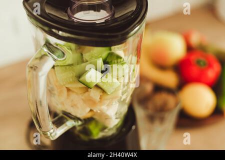 Mixeur fixe avec ingrédients pour un smoothie sain sur une table dans la cuisine Banque D'Images
