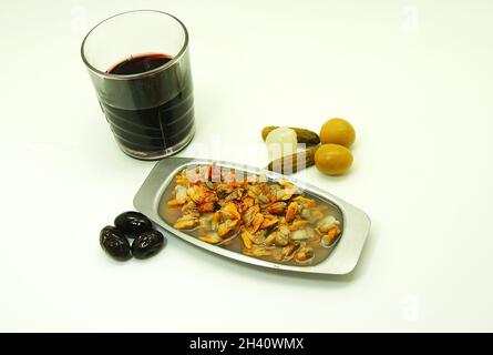 Des coques avec un verre de vin et des olives sur fond blanc Banque D'Images