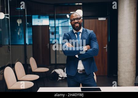 Portrait souriant homme d'affaires afro-américain en costume bleu au bureau Banque D'Images