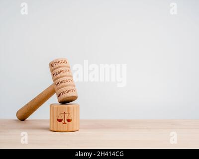 Un juge en bois Gavel avec des mots, l'éthique, le respect, l'honnêteté, et l'intégrité avec le tableau de son avec l'icône de balance, jouets sur table en bois, fond blanc Banque D'Images