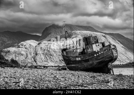 Bateau de pêche abandonné à Corpach sur la plage du Loch Linnhe à fort William dans les Highlands écossais vu ici avec Ben Nevis dans la distance Banque D'Images