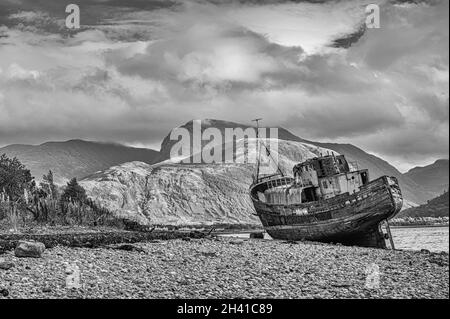 Bateau de pêche abandonné à Corpach sur la plage du Loch Linnhe à fort William dans les Highlands écossais vu ici avec Ben Nevis dans la distance Banque D'Images