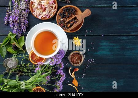 Bannière de thé avec des herbes, des fleurs et des fruits, top shot sur un fond en bois Banque D'Images