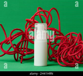 Flacon en plastique blanc avec distributeur pour cosmétiques sur fond vert.Vierge pour les produits de marque, hydratant Banque D'Images