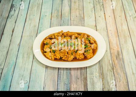 chifa recette péruvienne qui est une recette classique de poulet tausí avec légumes croquants et sauce soja sur table en bois Banque D'Images