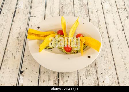 Délicieux guacamole mexicain aux graines de sésame, aux tomates cerises et à la banane croquante Banque D'Images