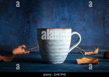 L'automne encore la vie avec une tasse de thé, les feuilles d'automne, et la pluie Banque D'Images
