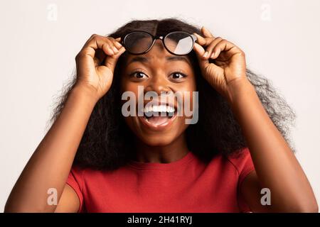 Offre exceptionnelle.Surprise Black femme prenant des lunettes dans étonnement Banque D'Images