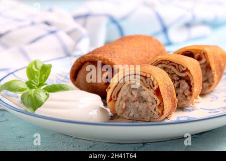 Crêpes à la viande hachée et sauce à la crème aigre. Banque D'Images