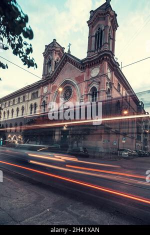 Voitures fraîches à longue exposition circulation néons sentiers de lumière, vue de nuit sur la route, Rome, Italie.En face de Chiesa di Santa Maria Immacolata all'Esquilino Banque D'Images