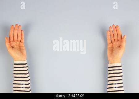 Deux mains de paume de femme vides ouvertes sur fond gris clair.Vue de dessus, espace de copie pour le texte Banque D'Images