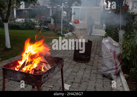 Morceaux de bois empilés dans un grill brûlant dans un feu d'orange.Préparation du gril la nuit.Heure du dîner. Banque D'Images