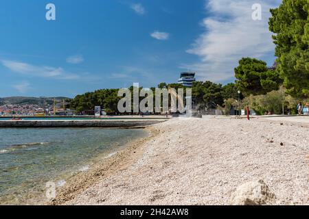 Vodice, Croatie-5 juin 2021: Petite pelle réparant la plage de sable après de fortes marées avant la saison touristique d'été commence sur la côte croate Banque D'Images