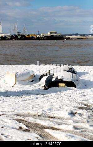 Des bateaux à rames ont été laissés amarrés sur la plage sur la côte du Suffolk.Ils ont été couverts de neige après une rare tempête de neige qui couvre la région Banque D'Images