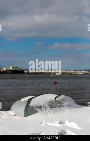 Des bateaux à rames ont été laissés amarrés sur la plage sur la côte du Suffolk.Ils ont été couverts de neige après une rare tempête de neige qui couvre la région Banque D'Images