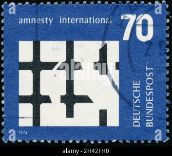 POLTAVA, UKRAINE - 31 octobre 2021.Timbre d'époque imprimé en Allemagne vers 1974 montre le texte d'Amnesty International Banque D'Images