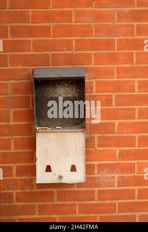 2021 août - ancien casier à cigarettes cassé monté sur un mur en brique rouge. Banque D'Images