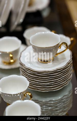 Videz les assiettes et les bols.Mise au point sélective.Tasse et assiettes sur table, tasse de café.Vaisselle de différentes formes.Un ensemble d'assiettes et de mugs. Banque D'Images