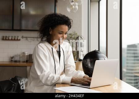 Bonne jeune femme d'affaires africaine travaillant sur l'ordinateur. Banque D'Images