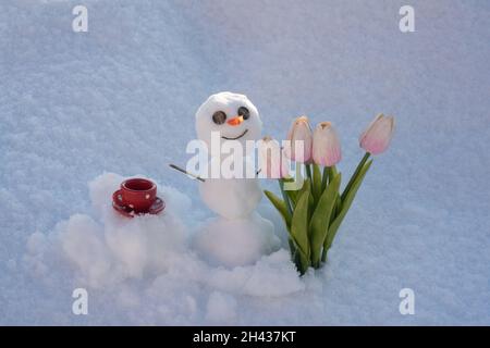 Au revoir hiver Bonjour printemps.Bonhomme de neige avec tasse à café.Bonhomme de neige avec fleurs. Banque D'Images