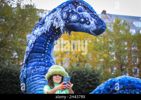 Grosvenor Square, Londres, Royaume-Uni.31 octobre 2021.Les gens regardent et posent avec désordre le monstre NESS de COP.Le désordre est entièrement fait à partir de jeans recyclés et d'autres matériaux durables, et sera sur Grosvenor Square jusqu'à novembre 12.La sculpture est une collaboration entre l'artiste Billie Achilleos, plate-forme de streaming WaterBear et MUD Jeans, une marque circulaire de denim.Credit: Imagetraceur/Alamy Live News Banque D'Images