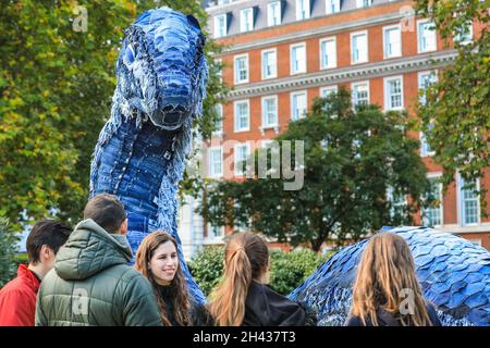 Grosvenor Square, Londres, Royaume-Uni.31 octobre 2021.Les gens regardent et posent avec désordre le monstre NESS de COP.Le désordre est entièrement fait à partir de jeans recyclés et d'autres matériaux durables, et sera sur Grosvenor Square jusqu'à novembre 12.La sculpture est une collaboration entre l'artiste Billie Achilleos, plate-forme de streaming WaterBear et MUD Jeans, une marque circulaire de denim.Credit: Imagetraceur/Alamy Live News Banque D'Images