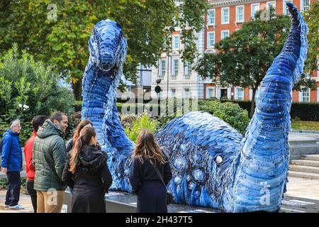 Grosvenor Square, Londres, Royaume-Uni.31 octobre 2021.Les gens regardent et posent avec désordre le monstre NESS de COP.Le désordre est entièrement fait à partir de jeans recyclés et d'autres matériaux durables, et sera sur Grosvenor Square jusqu'à novembre 12.La sculpture est une collaboration entre l'artiste Billie Achilleos, plate-forme de streaming WaterBear et MUD Jeans, une marque circulaire de denim.Credit: Imagetraceur/Alamy Live News Banque D'Images