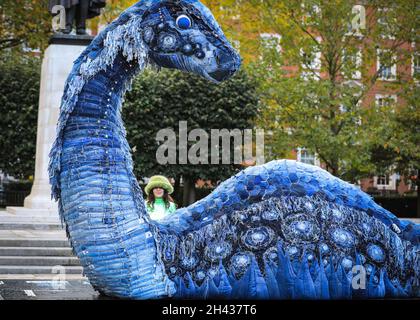 Grosvenor Square, Londres, Royaume-Uni.31 octobre 2021.Les gens regardent et posent avec désordre le monstre NESS de COP.Le désordre est entièrement fait à partir de jeans recyclés et d'autres matériaux durables, et sera sur Grosvenor Square jusqu'à novembre 12.La sculpture est une collaboration entre l'artiste Billie Achilleos, plate-forme de streaming WaterBear et MUD Jeans, une marque circulaire de denim.Credit: Imagetraceur/Alamy Live News Banque D'Images