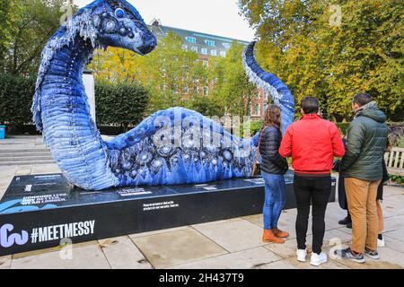 Grosvenor Square, Londres, Royaume-Uni.31 octobre 2021.Les gens regardent et posent avec désordre le monstre NESS de COP.Le désordre est entièrement fait à partir de jeans recyclés et d'autres matériaux durables, et sera sur Grosvenor Square jusqu'à novembre 12.La sculpture est une collaboration entre l'artiste Billie Achilleos, plate-forme de streaming WaterBear et MUD Jeans, une marque circulaire de denim.Credit: Imagetraceur/Alamy Live News Banque D'Images