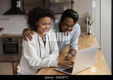 Un jeune couple afro-américain heureux utilisant un ordinateur. Banque D'Images