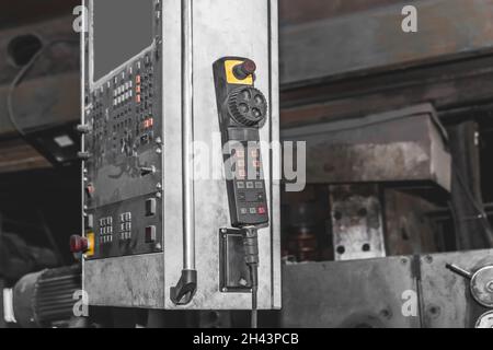 Grand ancien bouclier avec boutons et grue de mécanisme de levage du panneau de commande dans l'atelier de l'usine industrielle. Banque D'Images