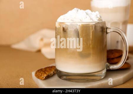 Verre de hojicha latte glacé sur fond beige, gros plan Banque D'Images