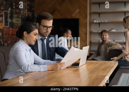 Jeunes employés de race mixte concentrés travaillant au bureau. Banque D'Images