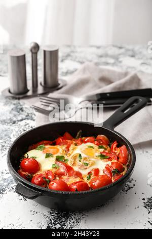 Poêle avec Shakshouka savoureux sur table Banque D'Images
