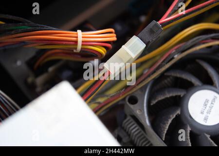 Homme à la main mettant les connexions électriques d'un ordinateur dans les prises de droite pour faire fonctionner l'ordinateur correctement.Connexions du câble d'alimentation. Banque D'Images