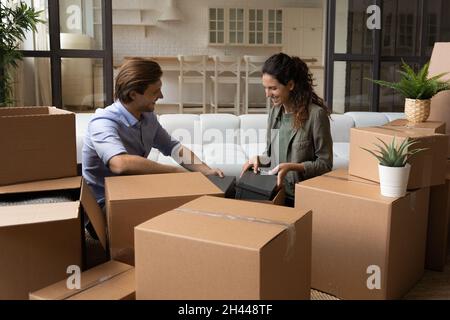 Les heureux couples emballent leurs effets personnels dans des boîtes en carton en vue de leur déménagement Banque D'Images