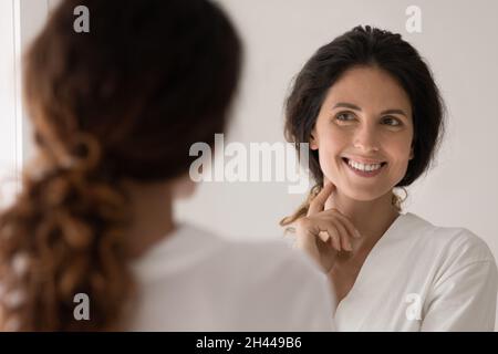 Belle femme admirez la vue sur le visage en regardant dans le miroir Banque D'Images