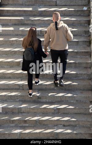 Belgrade, Serbie - 25 octobre 2020 : jeune couple marchant dans les escaliers publics extérieurs, vue en grand angle depuis l'arrière Banque D'Images