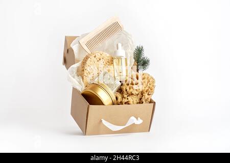 Éponges de mer naturelles, soupe, bouteille cosmétique avec huile dans une boîte artisanale sur blanc Banque D'Images