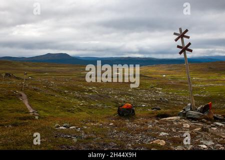 Un panneau de motoneige d'hiver et un marqueur orange d'été de la piste Kungsleden entre Viterskalet et Syter Huts, dans le nord de la Suède, en août. Banque D'Images